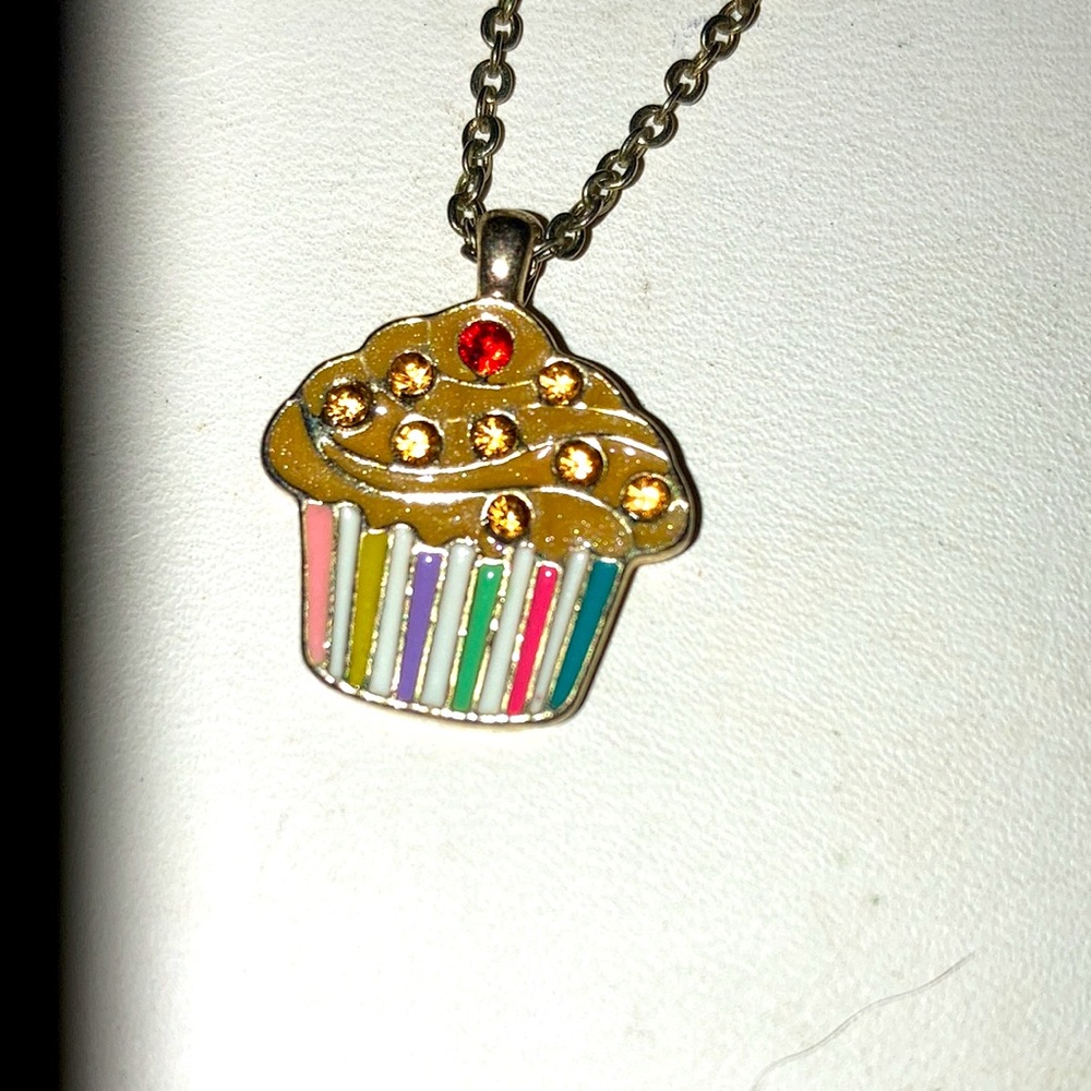 Cupcake pendant on gold chain. Previously owned. Tiny knot in chain.  Gold tone